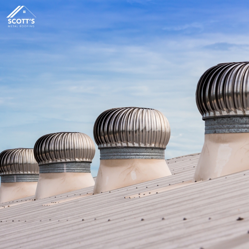 Metal Roof Ventilation NSW– Spinning turbine vents on a corrugated metal roof improve airflow and cooling under a clear blue sky.