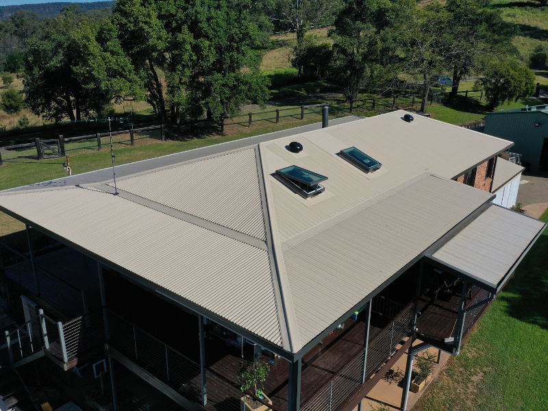 Beige metal roof with skylights, demonstrating longevity and factors affecting metal roof lifespan in rural settings.