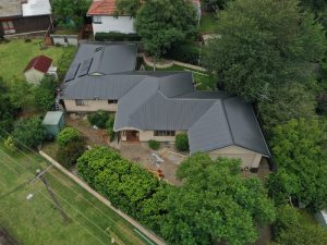 Aerial view of a house with a newly installed metal roof, highlighting the importance of a metal roof installation permit.