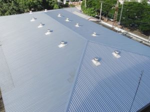 High-angle view of a large metal roof showcasing the benefits of metal roofing: durability and sleek design.