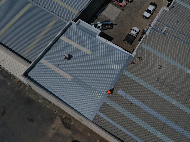 Aerial view of a commercial building showcasing the durable and long-lasting benefits of metal roofing.